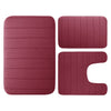 A set of three rectangular plush memory foam bath mats in a dusty rose color.
