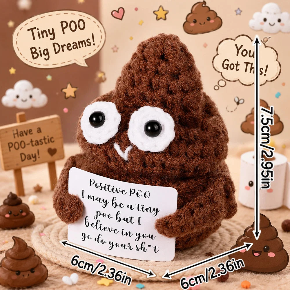 A handmade crochet brown stuffed animal resembling a poo with a sign and surrounding small candies.