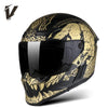 A black full-face motorcycle helmet with gold and black graphic designs and a clear visor.