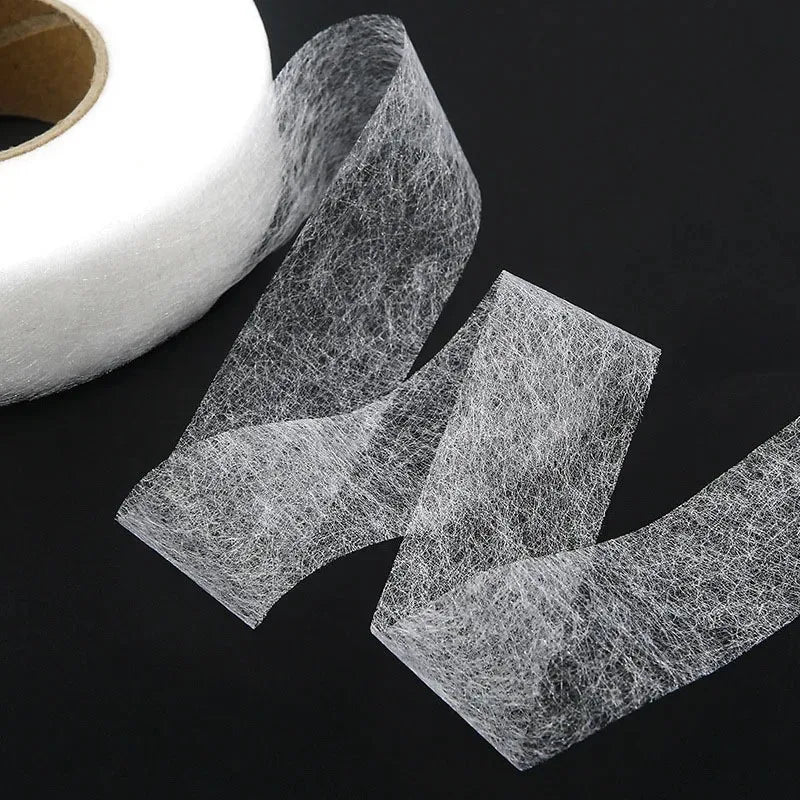 Roll of clear double-sided iron-on adhesive tape for fabric hemming and repairs