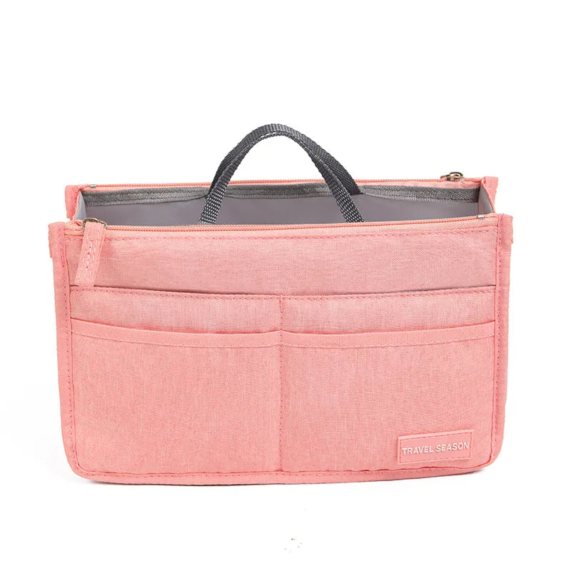 A pink purse organizer insert with multiple compartments and a handle.