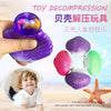 A hand holds a purple mermaid shell squeeze toy, with a child smiling next to an open white shell.
