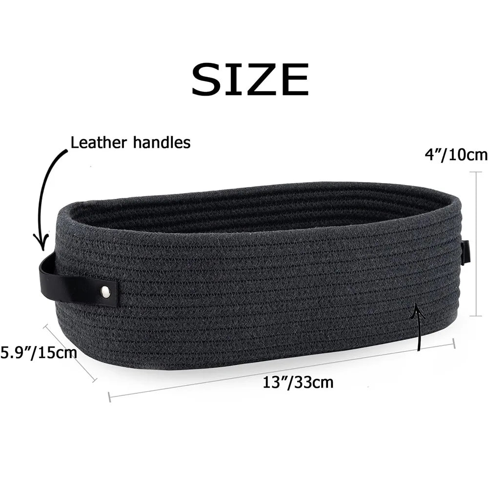 A dark gray woven cotton rope storage basket with leather handles shown flat.