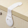 White multi-purpose baby safety strap attached to a cabinet drawer handle.