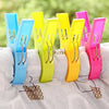 A collection of colorful heavy-duty laundry clips in blue, yellow, and pink are shown on a white surface.