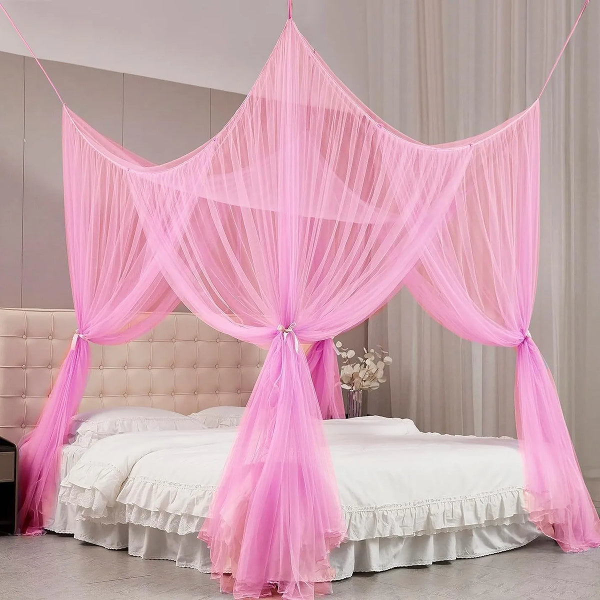 Pink sheer mosquito net draped over a bed for protection