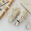A white lace double-layer folding umbrella with a striped handle is shown on a light surface.