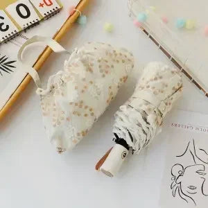 A white lace double-layer folding umbrella with a striped handle is shown on a light surface.