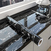 Roll of black marble peel-and-stick film displayed on a kitchen countertop with a stovetop.
