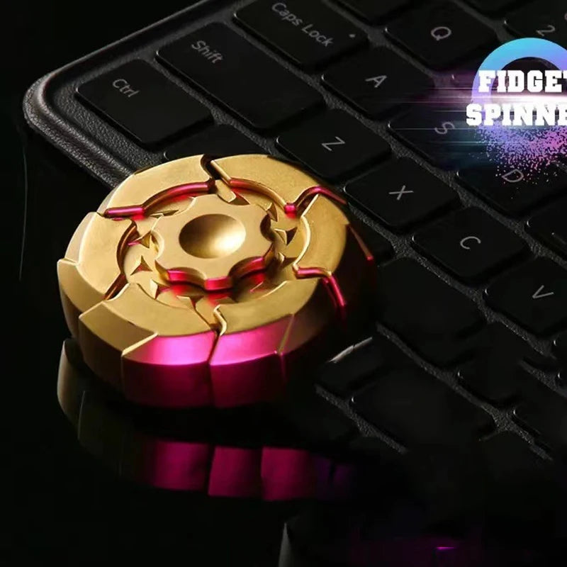 A gold and magenta magnetic fidget slider resting on a black laptop keyboard.