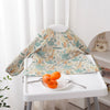 A long-sleeve waterproof baby bib with a cute animal design featuring various jungle animals on a white tray.
