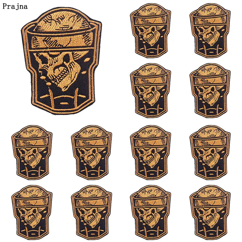 A set of ten embroidered iron-on patches featuring skull and horror designs in gold and black.