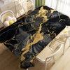 Black gold marble waterproof tablecloth displayed on a table with white wicker chairs.