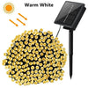 A cluster of warm white solar powered outdoor string lights with numerous LED bulbs.