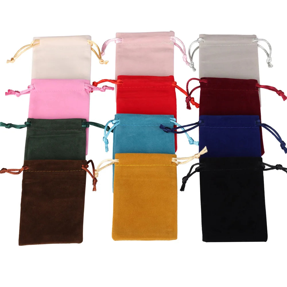 A collection of velvet drawstring jewelry pouches in various colors including pink, red, blue, green, and black.