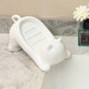 White cat-shaped soap dish with a drainage tray sitting on a marble countertop.