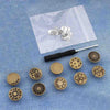 A small silver snap button kit is displayed on a translucent plastic bag with loose jeans.
