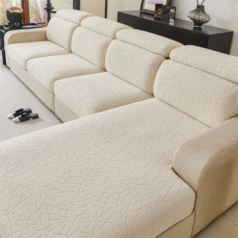 A light beige sectional sofa cover featuring a textured jacquard fleece fabric with a subtle geometric pattern.