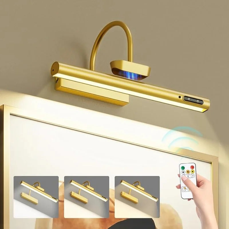 A gold-colored cordless rechargeable picture light fixture mounted on a wall, shown with close-up views of its installation.