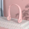A pink hands-free bladeless neck fan with a digital display is shown resting on a textured surface.
