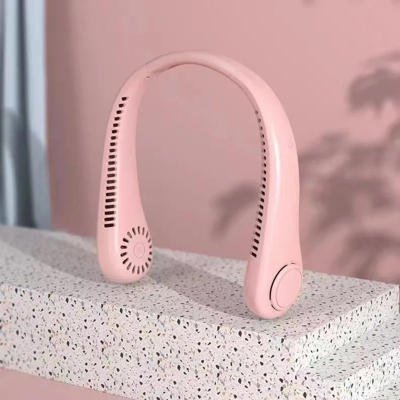 A pink hands-free bladeless neck fan with a digital display is shown resting on a textured surface.