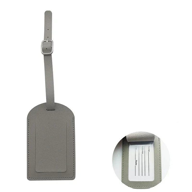 A rectangular gray PU leather luggage tag with a metal clip attached.
