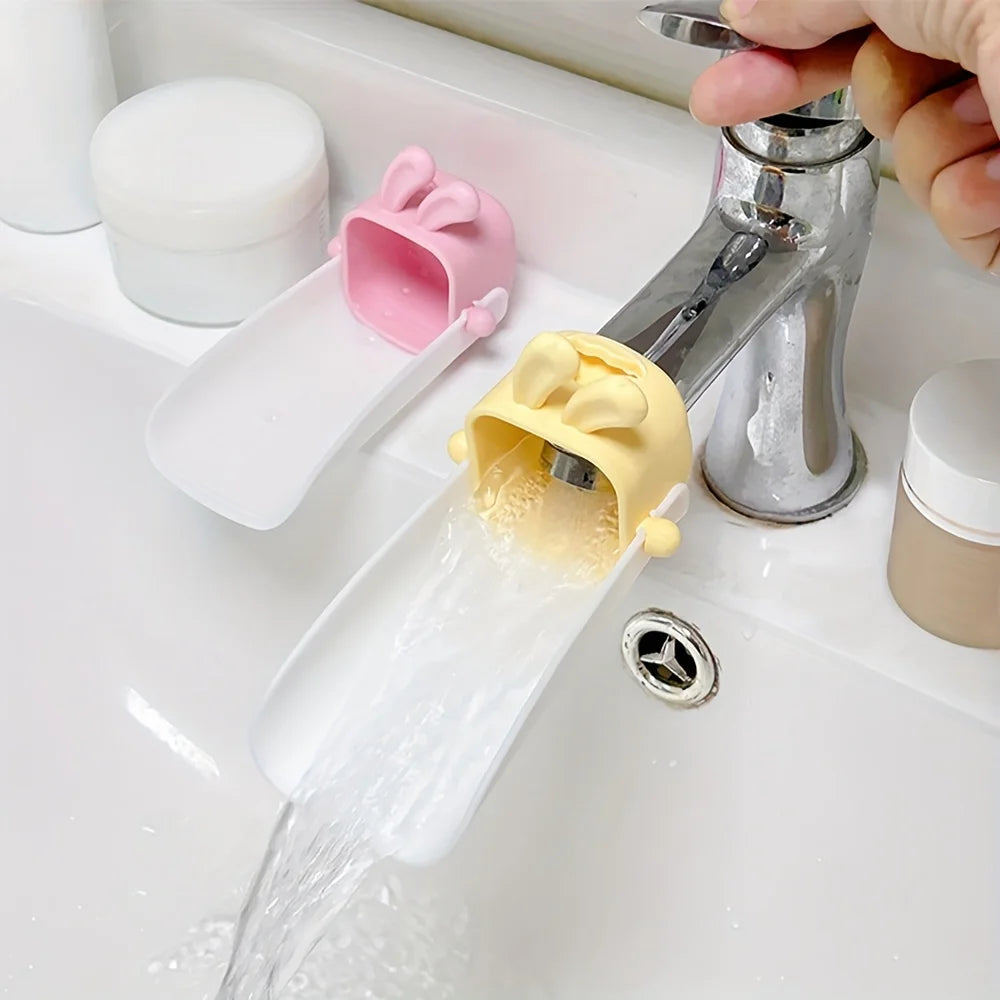 A rabbit-themed anti-splash faucet extender is shown dispensing water from a sink faucet.