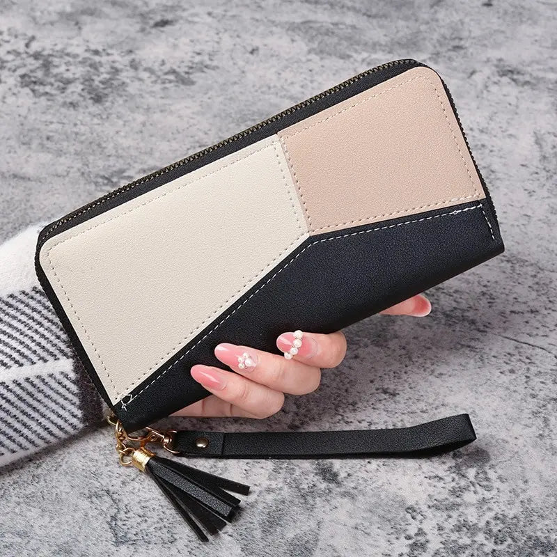 A beige and black checkered women's long zip-around PU leather wallet with card slots being held by a hand.