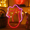 A pink LED lip neon sign shaped like a woman's face is displayed on a table.