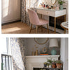 A vintage floral curtain with tassels hangs next to a white fireplace mantel decorated with plants and gold accents.