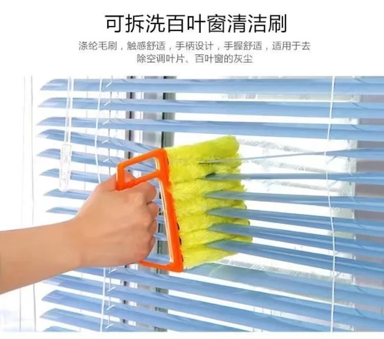 An orange dusting brush is cleaning the slats of a blue horizontal blind.