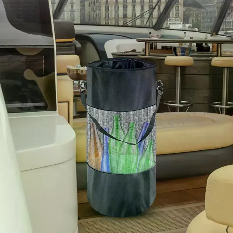 A dark gray mesh trash bag with a carabiner clip is displayed in a modern interior setting.