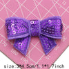 Purple sequin bow patches for DIY crafts shown on a pink grid background