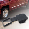 Black trailer hitch receiver cover with a flag emblem lying on a white surface.
