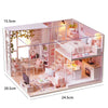 A detailed miniature wooden dollhouse building kit featuring furniture and decorative elements.