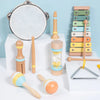 A set of wooden percussion instruments including a tambourine, wooden mallets, and a maraca displayed on a white surface.