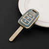 A teal and gold protective TPU key fob cover for a Honda vehicle is shown resting on a white plate.