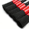 A set of red and black car detailing brushes with soft bristles for interior and wheels.
