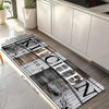 A rectangular kitchen mat featuring a distressed wood grain design with black and white accents placed on a light wooden floo