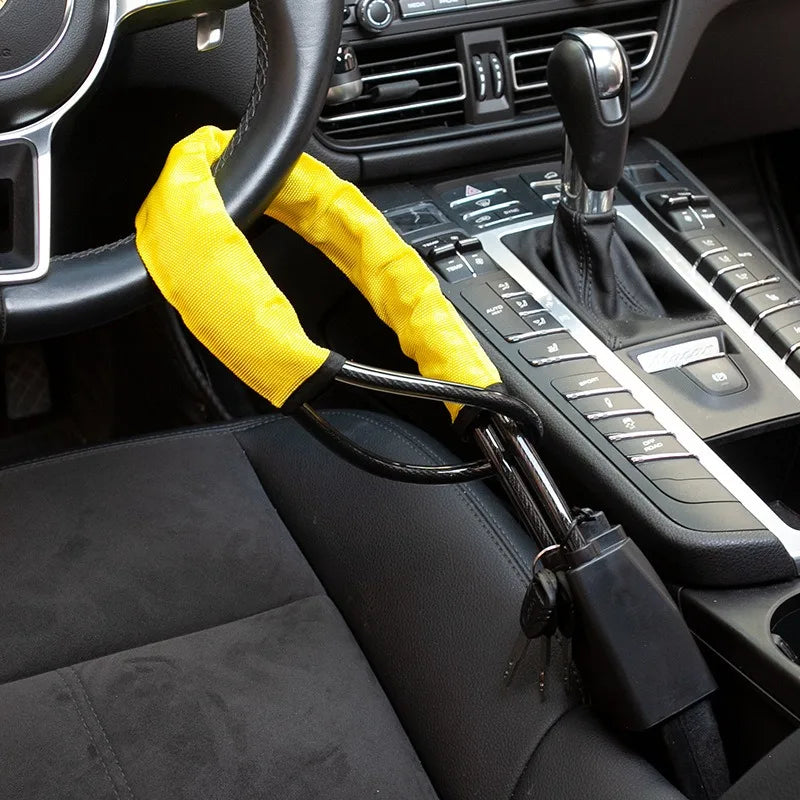 Verrou universel jaune avec sangle noire et ancrage ceinture de sécurité dans l'habitacle d'une voiture.