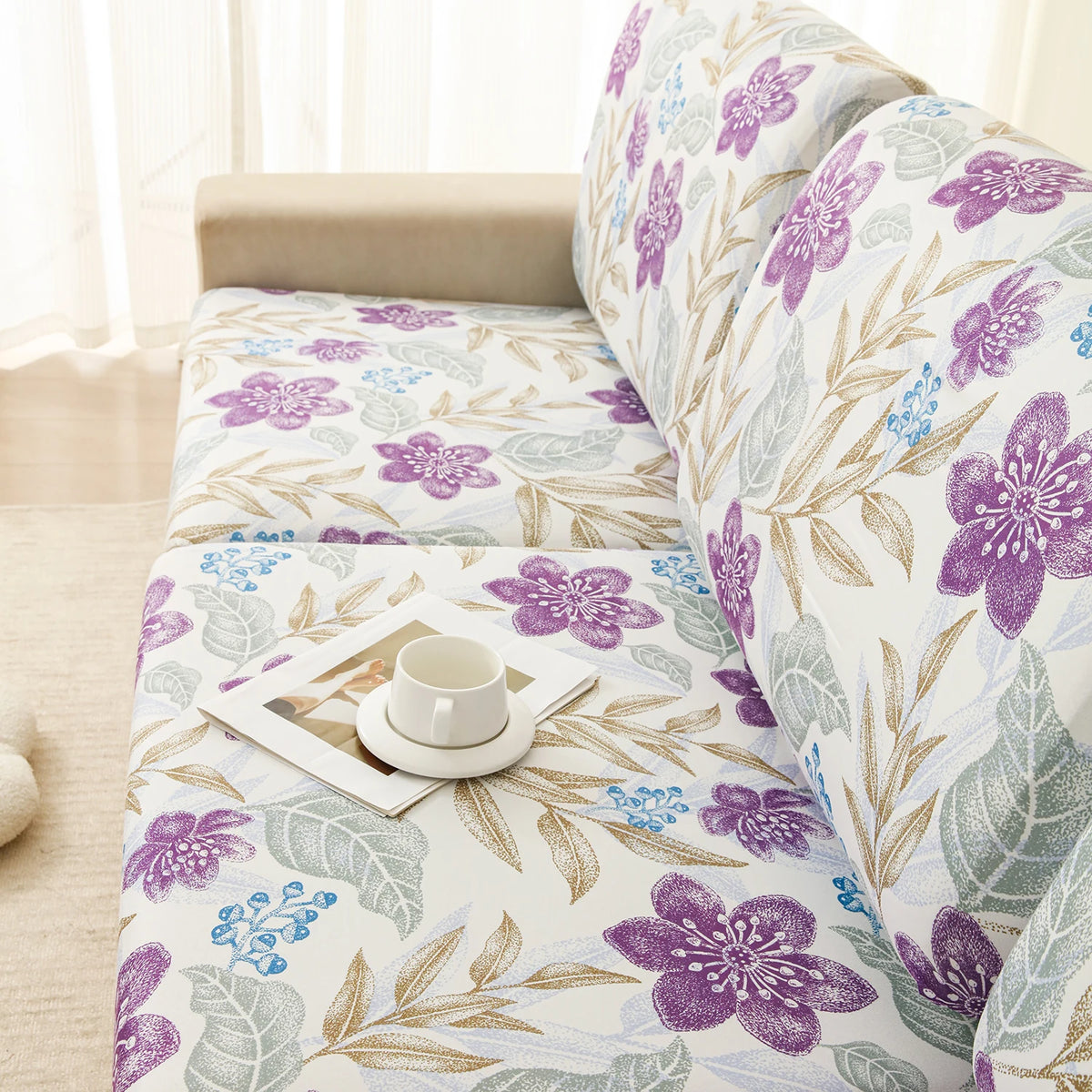 A floral elastic sofa cover featuring purple and green botanical patterns on a light-colored fabric.