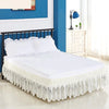 White bed skirt with lace trim and elastic band on a white bed frame
