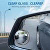 A close-up view of a car's side mirror showing a reversed auxiliary blind spot mirror.