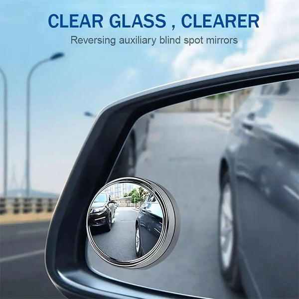 A close-up view of a car's side mirror showing a reversed auxiliary blind spot mirror.