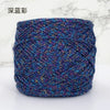 A ball of metallic silk crochet yarn with a vibrant blue and purple shimmer for knitting and macrame.
