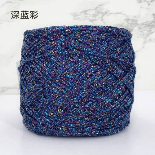 A ball of metallic silk crochet yarn with a vibrant blue and purple shimmer for knitting and macrame.