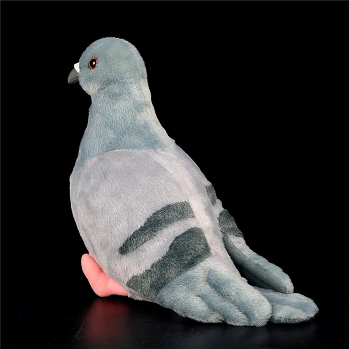 A soft gray pigeon plush toy with dark stripes, shown in a profile view against a black background.