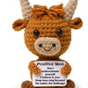 A handmade crochet pocket hug doll resembling a brown calf with horns and a smiling face.