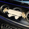 A crystal flower gravity car phone holder is mounted on a dark surface, showing its design and function.