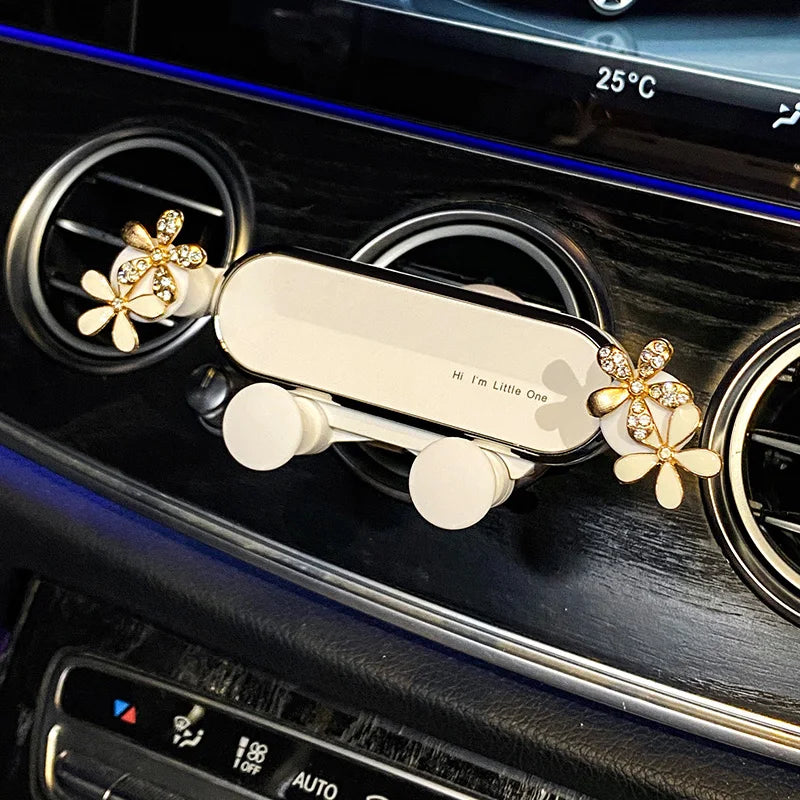 A crystal flower gravity car phone holder is mounted on a dark surface, showing its design and function.